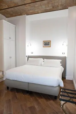 a white bedroom with a large bed with white pillows at Domus Vitra 23 in Rome