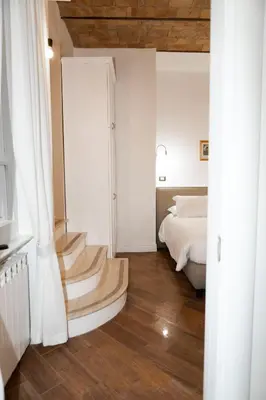a bedroom with a bed and a staircase in a room at Domus Vitra 23 in Rome