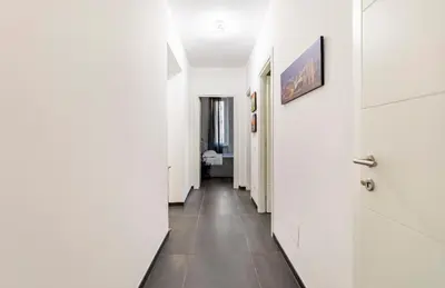 a hallway with white walls and a tile floor at Azzurra Guest House Vaticano in Rome