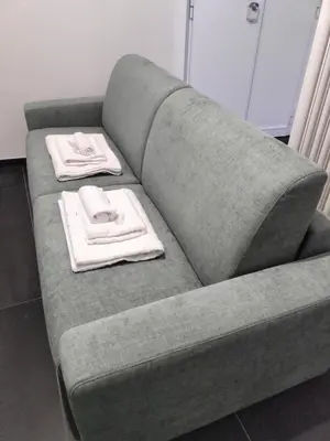 a gray couch with two towels on top of it at Azzurra Guest House Vaticano in Rome