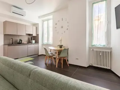 a living room with a couch and a table and a kitchen at Azzurra Guest House Vaticano in Rome
