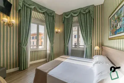 a bedroom with a bed with green curtains at HOTIDAY Room Collection - Roma Porta Pia in Rome