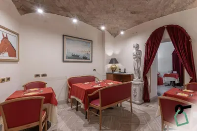 a dining room with a table and a statue at HOTIDAY Room Collection - Roma Porta Pia in Rome