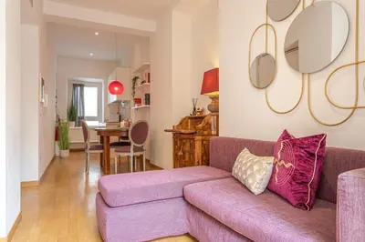 a living room with a purple couch and a dining room at Colosseum Oasis in Rome