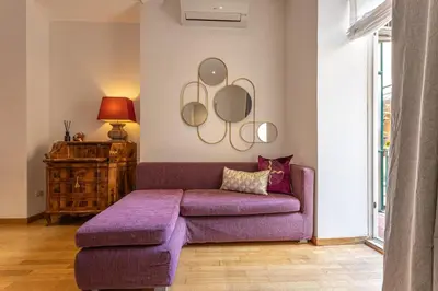a living room with a purple couch and a table at Colosseum Oasis in Rome