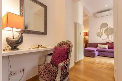 a living room with a chair and a mirror at Colosseum Oasis in Rome