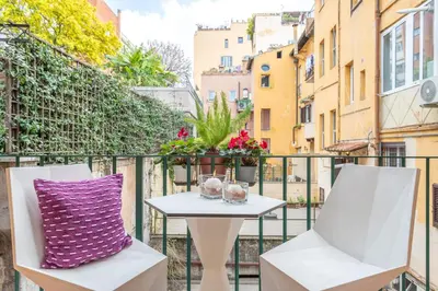 a table and chairs on a balcony with a purple pillow at Colosseum Oasis in Rome