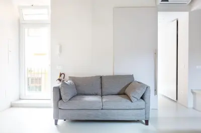 a gray couch in a white room with windows at Campo 13 Holiday Apartment in Rome