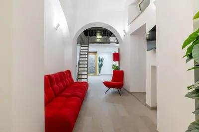 a living room with a red couch and two red chairs at Lovely studio Apartment - Capocci in Rome