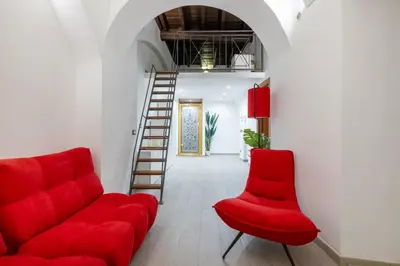 a living room with a red couch and a ladder at Lovely studio Apartment - Capocci in Rome