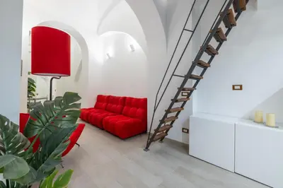 a living room with a red couch and a staircase at Lovely studio Apartment - Capocci in Rome