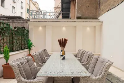 a table with chairs and a vase on top of it at Via Vespasiano Private Apartment in Rome