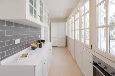 a large kitchen with white cabinets and windows at Via Vespasiano Private Apartment in Rome