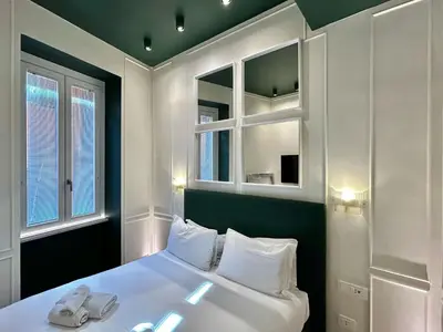 a bedroom with a white bed and two windows at PRIVATE LUXURY FONTANA DI TREVI in Rome
