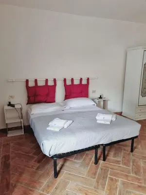 a bedroom with a large bed with red pillows at Borgo Dei Centurione in Rome