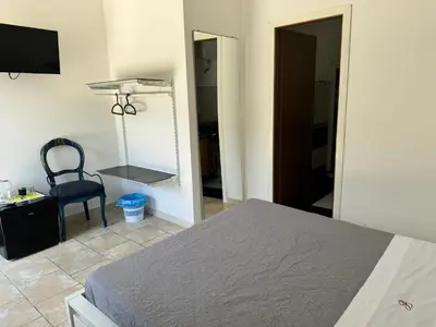 a bedroom with a bed and a chair and a mirror at Borgo Dei Centurione in Rome