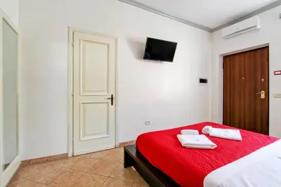 a bedroom with a red bed with two towels on it at Borgo Dei Centurione in Rome