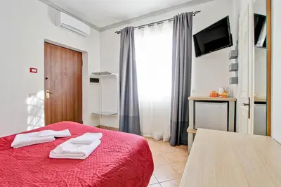 a bedroom with a red bed with two towels on it at Borgo Dei Centurione in Rome