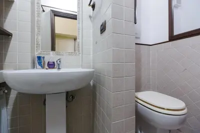 a bathroom with a sink and a toilet and a mirror at Cozy apartment in Rome