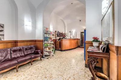 a living room with a leather couch and a bookstore at Hotel Giada Roma in Rome