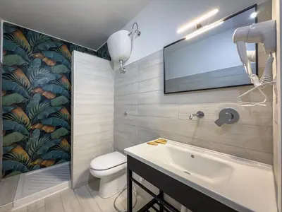 a bedroom with two beds and a tv on the wall at Hotel Giada Roma in Rome