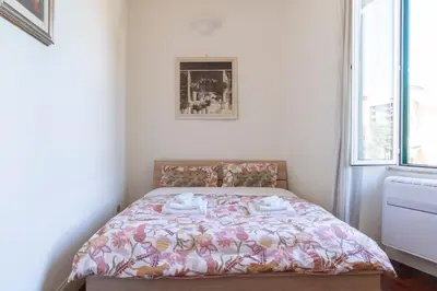 a bedroom with a bed with a floral bedspread at Casa di Amici alla Garbatella in Rome