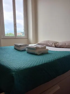 two towels sitting on top of a bed with a window at Casa di Amici alla Garbatella in Rome