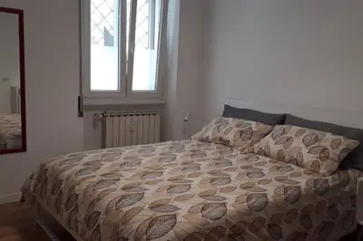 a bedroom with a bed with a comforter and a window at La Casetta di Monteverde in Rome