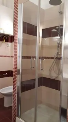 a bathroom with a glass shower with a toilet at La Casetta di Monteverde in Rome