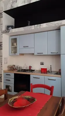a kitchen with white cabinets and a table with a plate on it at La Casetta di Monteverde in Rome
