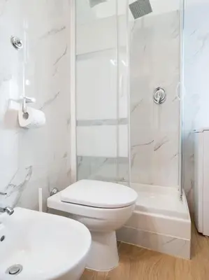 a white bathroom with a toilet and a shower at Home Holiday Rome - Basilica San Pietro in Rome