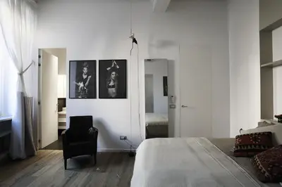 a white bedroom with a bed and a chair at Antiche Residenze Romane Pantheon in Rome