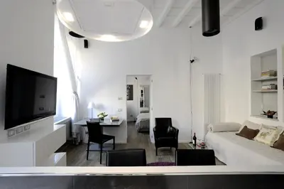 a white living room with a couch and a tv at Antiche Residenze Romane Pantheon in Rome