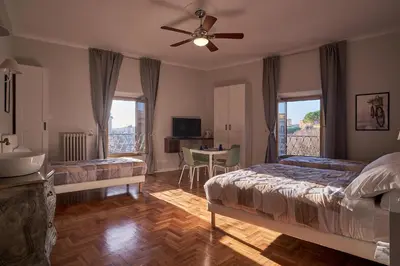 a bedroom with two beds and a table with a television at Bonavista inn in Rome
