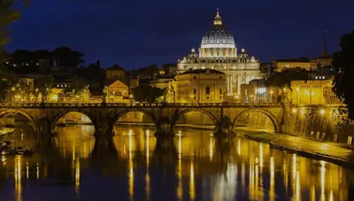 a bridge over a river in front of a building at House of the Sun in Trastevere in Rome
