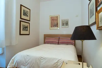 a small bedroom with a bed and a lamp at Gallery Apartment, Near The Vatican in Rome
