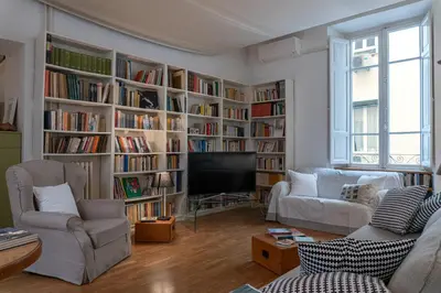 a living room with book shelves filled with books at Gallery Apartment, Near The Vatican in Rome
