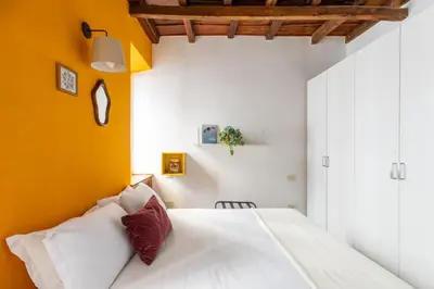 a bedroom with a white bed and a yellow wall at iFlat Classic And Contemporary Home in Rome