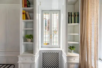 a white hutch with a window and plants in it at iFlat Classic And Contemporary Home in Rome