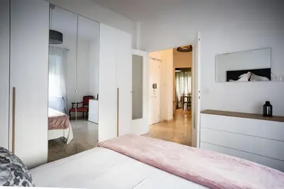 a bedroom with white walls and a bed with a mirror at Family house in Rome