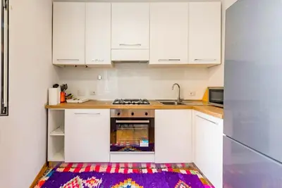 a kitchen with white cabinets and a rug on the floor at La Casa dello Scrittore - Writer's Home in Rome