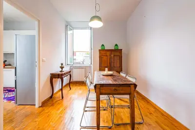 a room with a table and chairs and a kitchen at La Casa dello Scrittore - Writer's Home in Rome