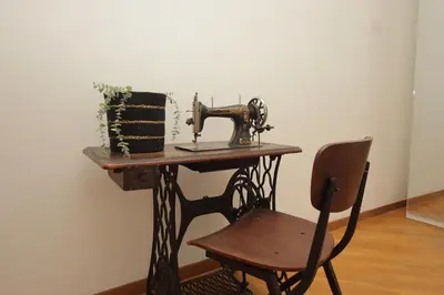 an old sewing machine sitting on a table with a chair at Giant Borghese Apartment in Rome