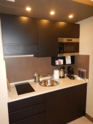 a kitchen with a sink and black cabinets at Domus Aurelia Studio Apartments in Rome