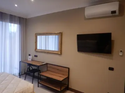 a bedroom with a bed and a desk and a television at Domus Aurelia Studio Apartments in Rome