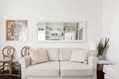 a white living room with a white couch at Re-Imagined Apartment in Historical Building in Rome