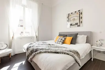 a white bedroom with a bed with a blanket on it at Re-Imagined Apartment in Historical Building in Rome