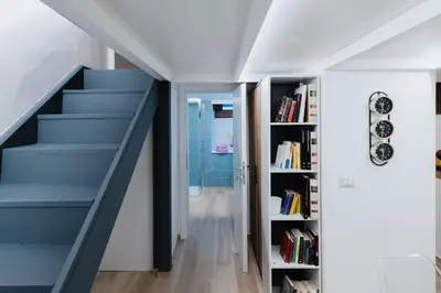 a staircase in a room with a book shelf at Modern loft in central Rome in Rome