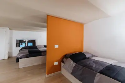 a bedroom with two beds and an orange wall at Modern loft in central Rome in Rome
