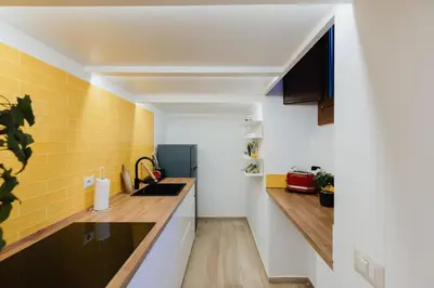 a kitchen with white and yellow walls and wooden countertops at Modern loft in central Rome in Rome